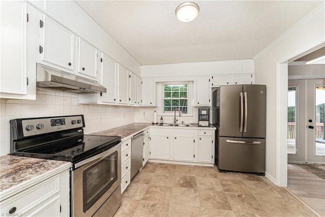 kitchen featuring appliances with stainless steel finishes, white cabinetry, tasteful backsplash, ornamental molding, and sink