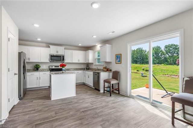141 Nova Ln, King, NC 27021 - kitchen with appliances with stainless steel finishes, a center island, a sink, recessed lighting, and white cabinetry