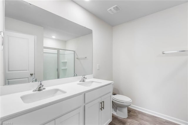 141 Nova Ln, King, NC 27021 - bathroom featuring wood finished floors, a stall shower, toilet, double vanity, and baseboards