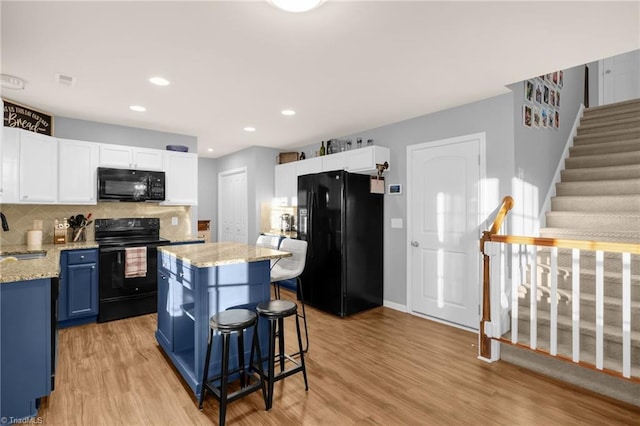 kitchen with white cabinetry, sink, black appliances, and blue cabinets