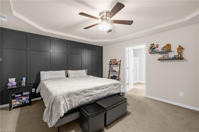 bedroom featuring a tray ceiling, ceiling fan, and light colored carpet