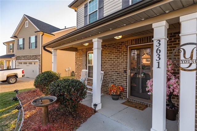 doorway to property featuring covered porch and a garage