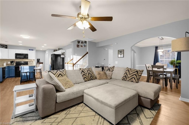 living room featuring light hardwood / wood-style flooring and ceiling fan