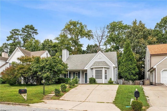 view of front of property with roof with shingles, a chimney, fence, driveway, and a front lawn