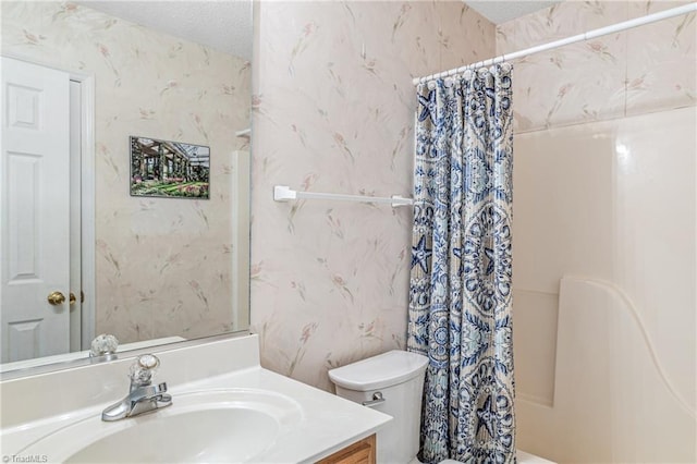 bathroom with shower / bathtub combination with curtain, toilet, a textured ceiling, vanity, and wallpapered walls