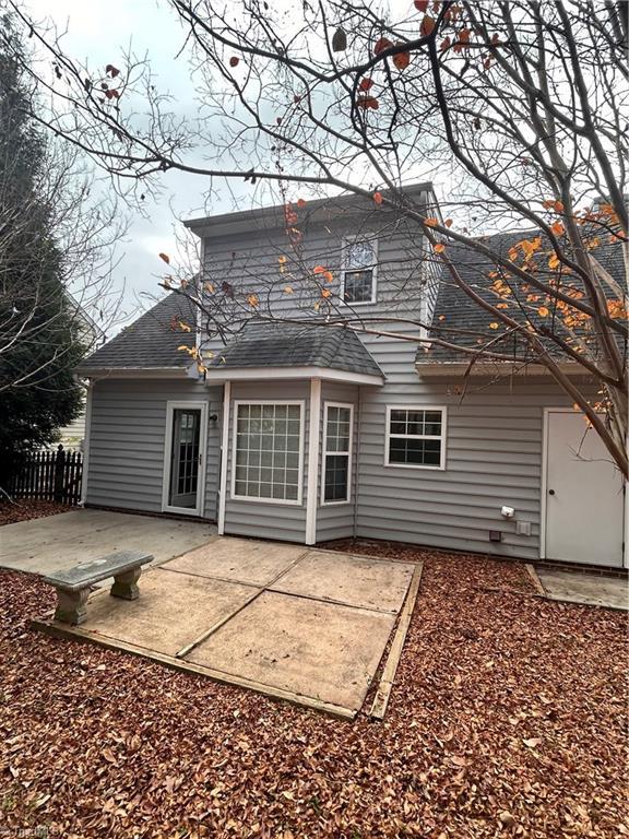 back of house featuring a patio, roof with shingles, and fence