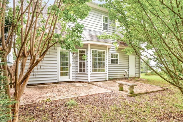 rear view of property featuring a patio area and roof with shingles