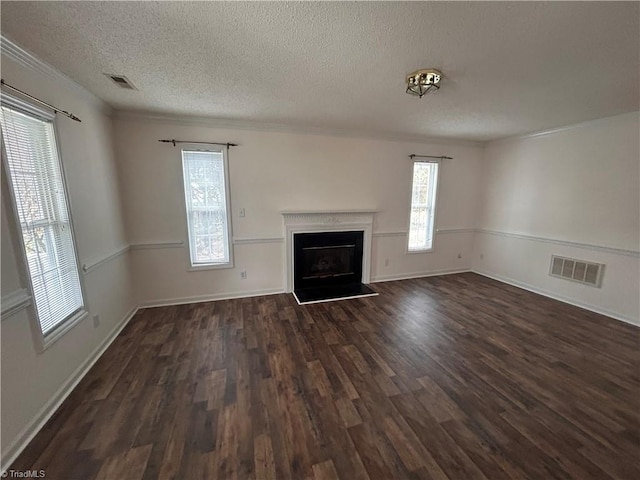 unfurnished living room with dark wood-style floors, a fireplace, visible vents, and a textured ceiling