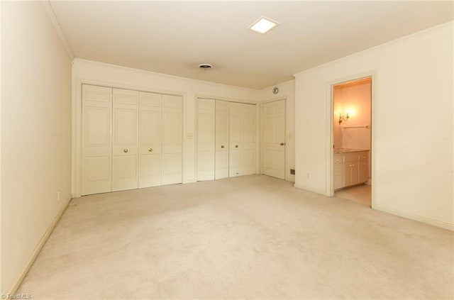 1300 Hobbs Rd, Greensboro, NC 27410 - unfurnished bedroom with two closets, ornamental molding, light carpet, baseboards, and ensuite bath