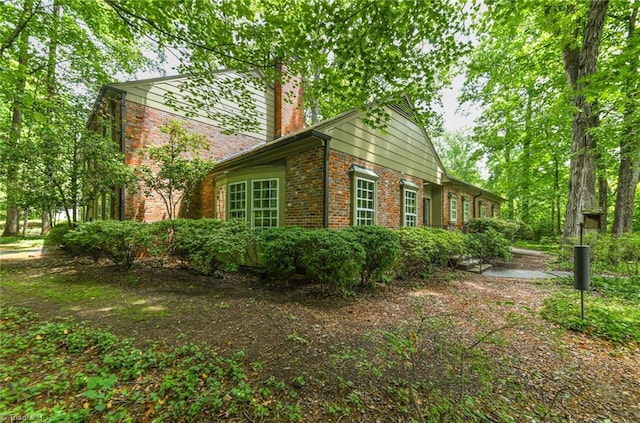 1300 Hobbs Rd, Greensboro, NC 27410 - view of side of home featuring brick siding and a chimney
