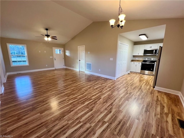 unfurnished living room featuring ceiling fan with notable chandelier, baseboards, visible vents, and light wood-style floors