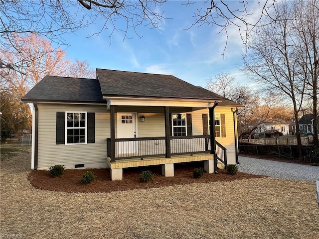 bungalow featuring a porch, a shingled roof, and driveway