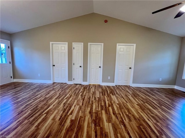 unfurnished bedroom featuring lofted ceiling, two closets, baseboards, and wood finished floors