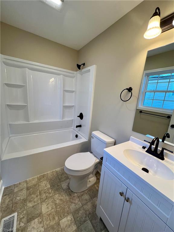 full bath featuring toilet,  shower combination, vanity, and visible vents