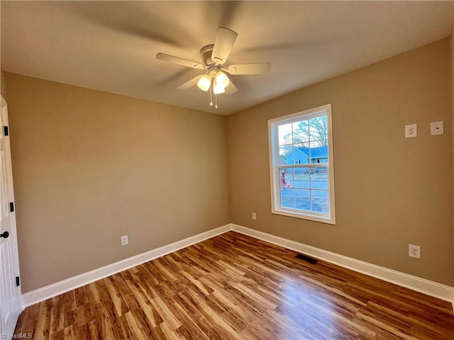 unfurnished room with visible vents, ceiling fan, baseboards, and wood finished floors