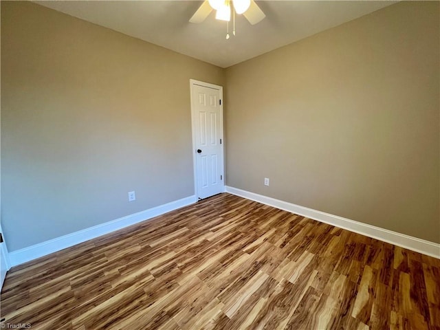 empty room featuring ceiling fan, baseboards, and wood finished floors