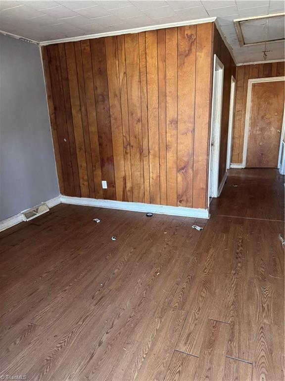 spare room featuring wood walls and hardwood / wood-style flooring