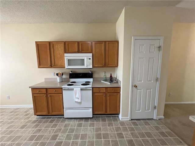 3931 Fountain Village Ln, High Point, NC 27265 - kitchen with white appliances, brown cabinetry, baseboards, light countertops, and a textured ceiling