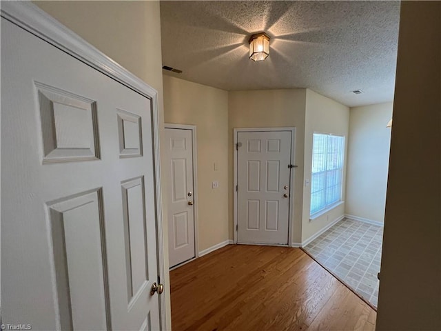 3931 Fountain Village Ln, High Point, NC 27265 - entryway with wood finished floors, a textured ceiling, and baseboards