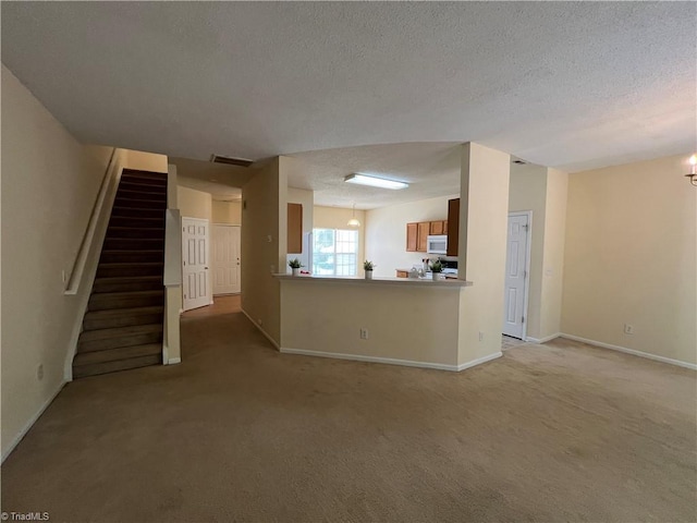 3931 Fountain Village Ln, High Point, NC 27265 - unfurnished living room featuring light colored carpet, a textured ceiling, baseboards, stairway, and a chandelier