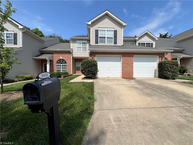 3931 Fountain Village Ln, High Point, NC 27265 - view of front of house with brick siding, driveway, a front yard, and a garage