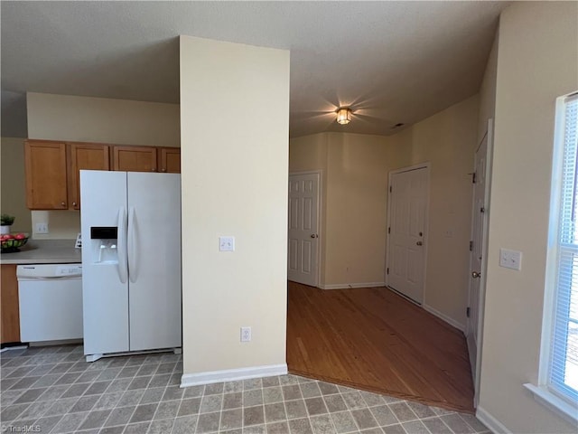 3931 Fountain Village Ln, High Point, NC 27265 - kitchen with white appliances, brown cabinets, light countertops, baseboards, and light wood-style floors