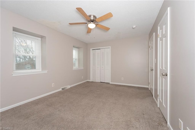 unfurnished bedroom featuring ceiling fan, light carpet, and a closet