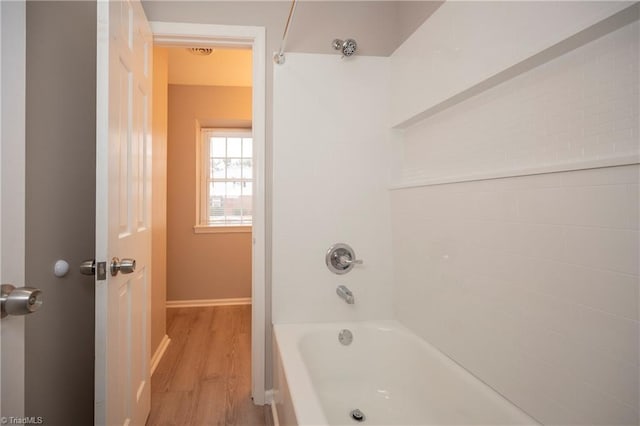 bathroom featuring wood-type flooring and tub / shower combination