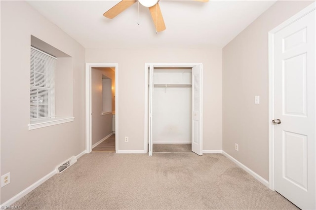 unfurnished bedroom featuring ceiling fan, light colored carpet, and a closet