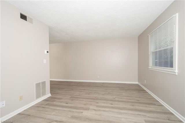 unfurnished room with light wood-type flooring