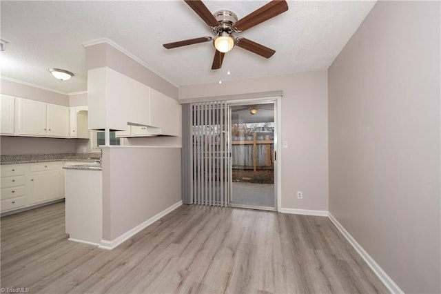 kitchen with ceiling fan, crown molding, light hardwood / wood-style floors, a textured ceiling, and white cabinets