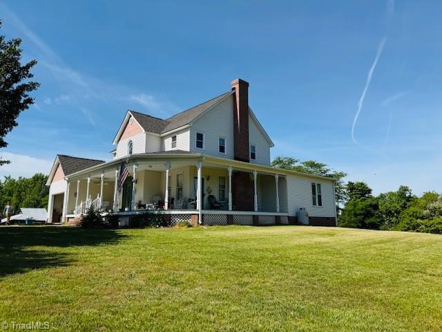 526 Bob Rainey Trl, Burlington, NC 27217 - view of side of home with a porch, a yard, a chimney, and an attached garage
