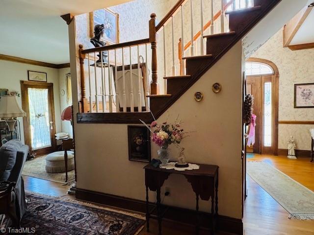 526 Bob Rainey Trl, Burlington, NC 27217 - stairs featuring wallpapered walls, wood finished floors, baseboards, and crown molding