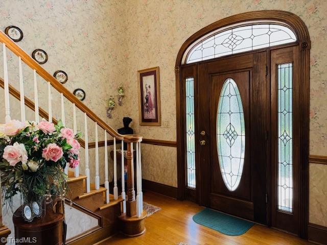 526 Bob Rainey Trl, Burlington, NC 27217 - entryway with wallpapered walls, wood finished floors, stairs, and healthy amount of natural light