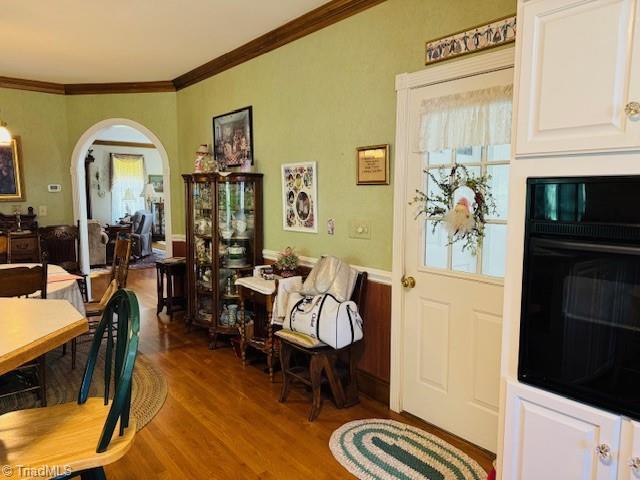 526 Bob Rainey Trl, Burlington, NC 27217 - dining room with wood finished floors, ornamental molding, arched walkways, and a wainscoted wall