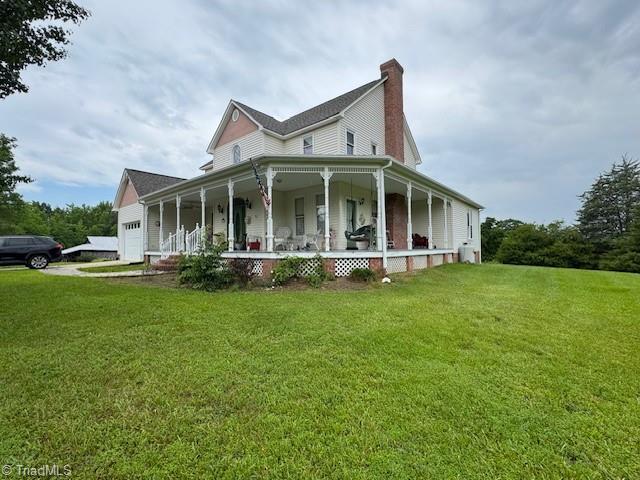 526 Bob Rainey Trl, Burlington, NC 27217 - view of home's exterior with a porch, a lawn, an attached garage, and a chimney