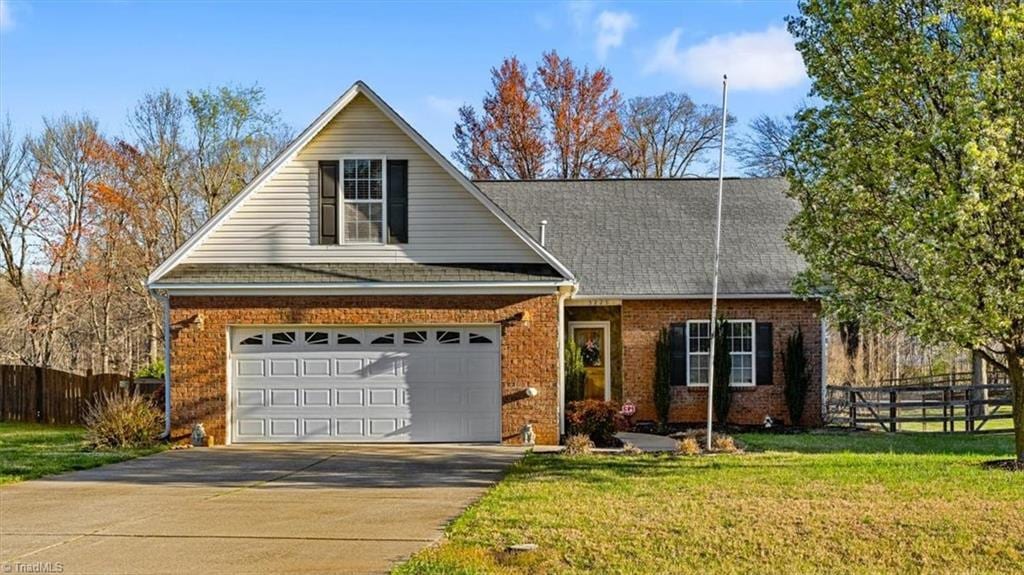 3225 Knoll Ridge Dr, Walkertown, NC 27051 - traditional-style home featuring driveway, a front yard, fence, brick siding, and a shingled roof