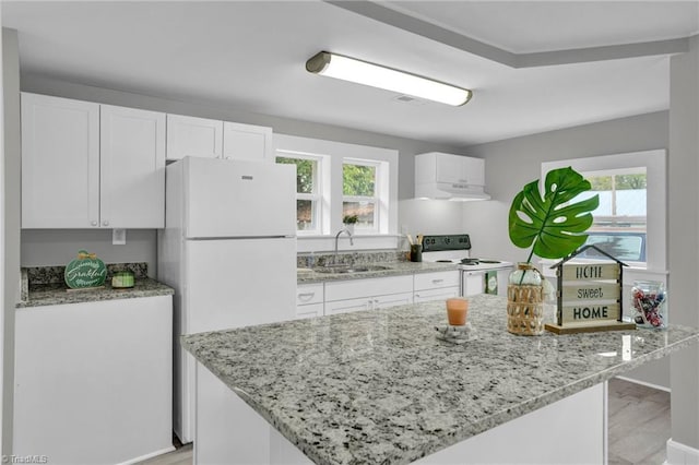 kitchen with plenty of natural light, white appliances, sink, and white cabinets