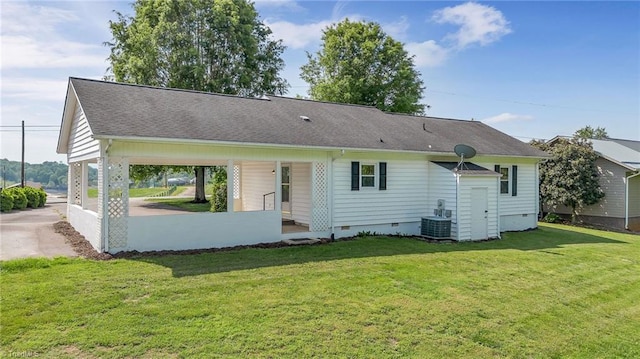 rear view of property featuring a lawn, a shingled roof, and crawl space