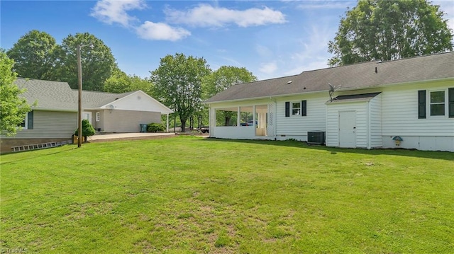 rear view of property featuring a yard, central air condition unit, and a patio area