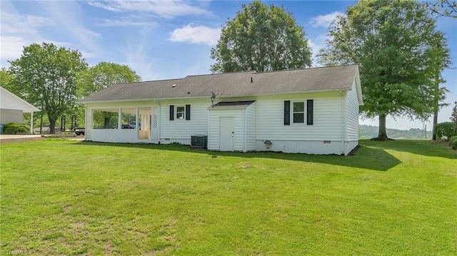 rear view of property featuring a yard, central AC unit, and crawl space