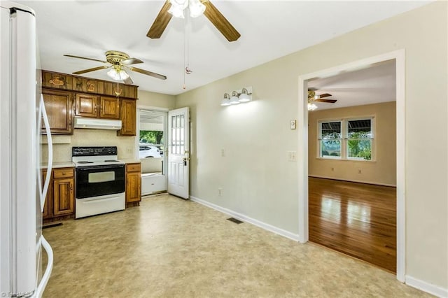 kitchen featuring under cabinet range hood, white appliances, a ceiling fan, and a wealth of natural light