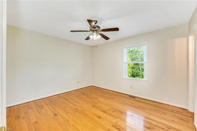 spare room featuring ceiling fan, baseboards, light wood-type flooring, and visible vents