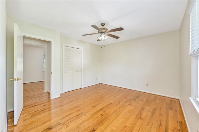 unfurnished bedroom with light wood-style flooring, baseboards, and a closet