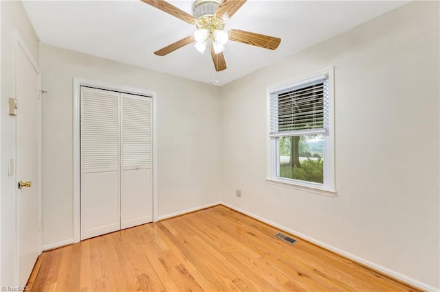 unfurnished bedroom with light wood-style flooring, a ceiling fan, a closet, visible vents, and baseboards