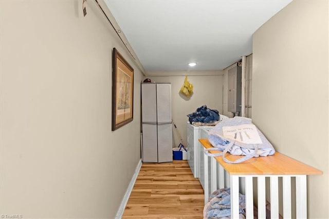 hall with light wood-type flooring and baseboards