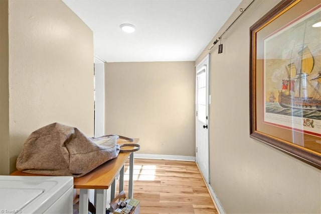 hallway with light wood-type flooring and baseboards