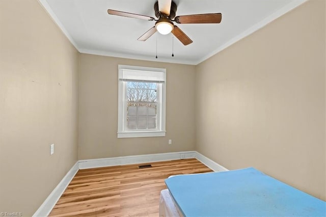 unfurnished bedroom featuring light wood-style flooring, baseboards, a ceiling fan, and ornamental molding