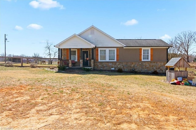 view of front of home featuring stone siding, a porch, and a front yard