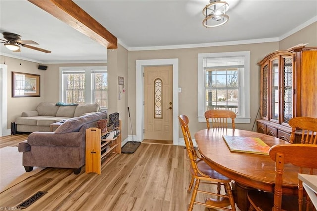 dining room featuring ornamental molding, light wood-type flooring, and a wealth of natural light